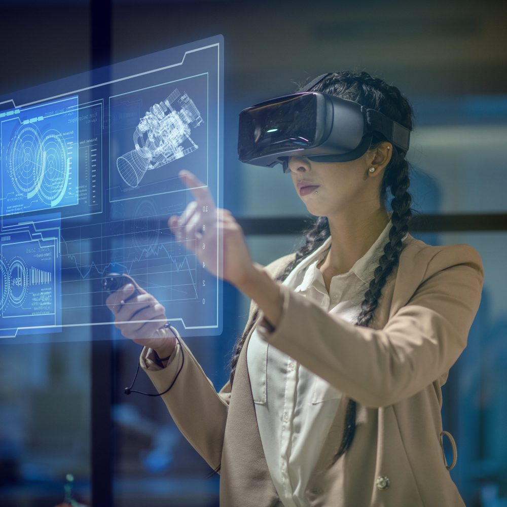 Female engineer wearing a virtual reality headset at work to explore an upcoming mechanical engineering project. She uses her hands to manipulate and explore the finer details.